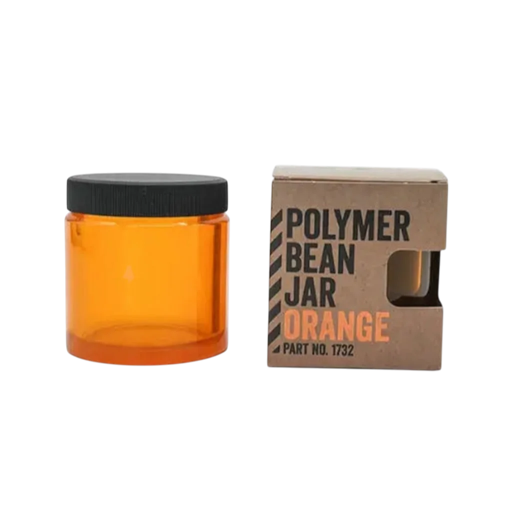 Comandante Ersatzbehälter in orange mit Deckel neben der Verpackung