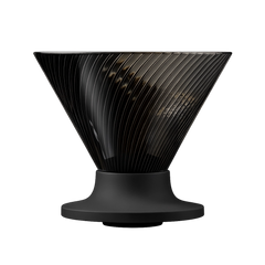 Eine direkte Seitenansicht des Hario V60 Dripper Neo vor weißem Hintergrund. Das Bild zeigt den dunkelgrauen, geriffelten, trichterförmigen Kaffee-Dripper, der auf einer soliden, schwarzen Basis steht.
